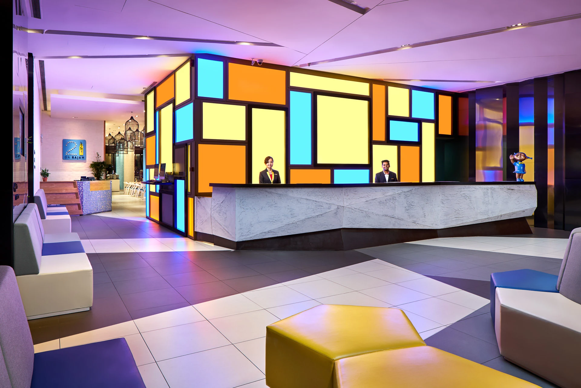 Wide lobby with geometric ottomans and illuminated partition