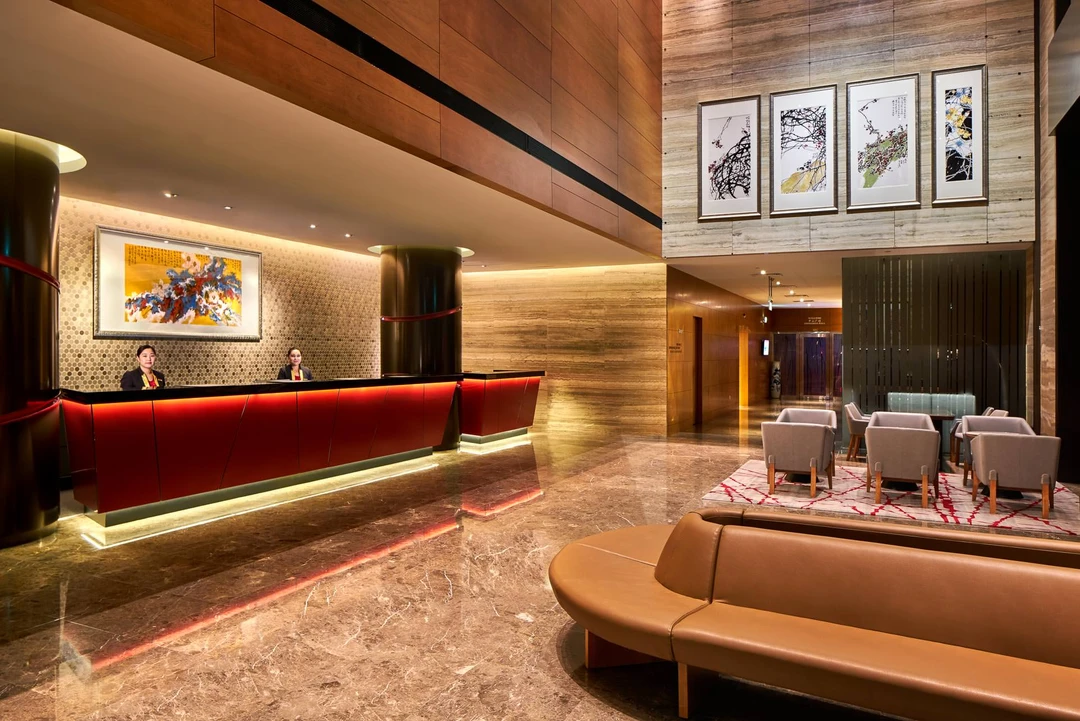 Double-height lobby with red reception counter and hexagonal mosaic wall