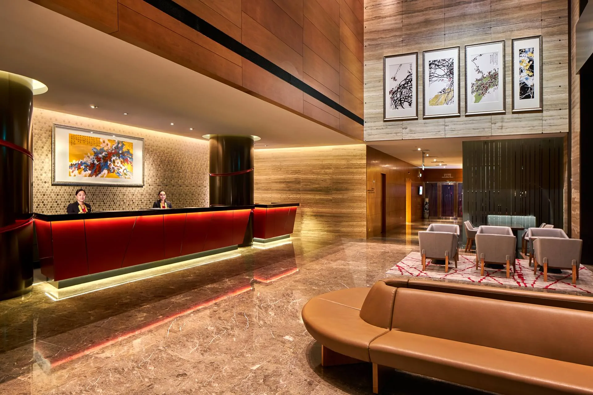 Double-height lobby with red reception counter and hexagonal mosaic wall