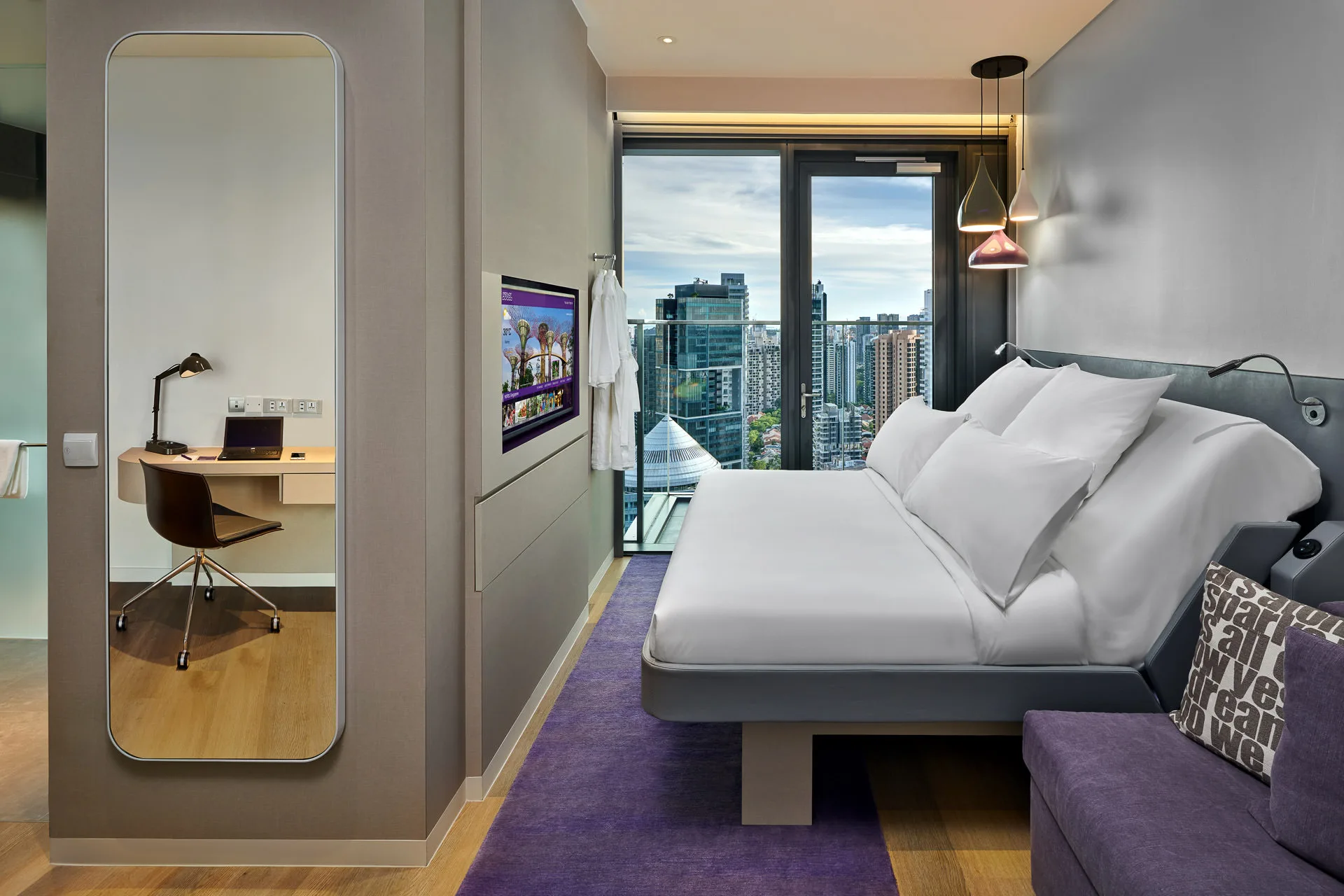 Compact queen room with city skyline view and pendant lamps