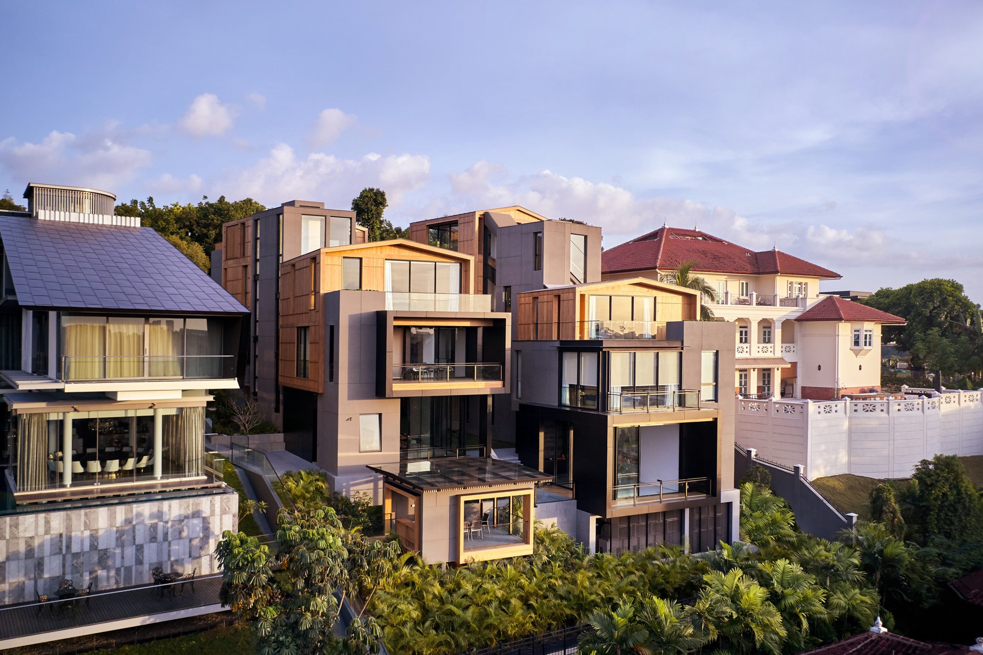 Modern residence with stacked timber volumes and colonial neighbour at golden hour