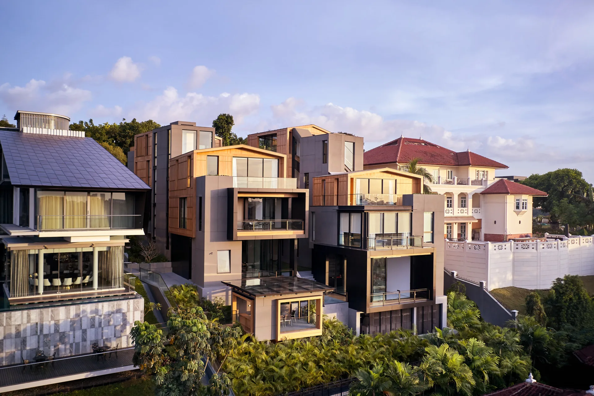 Modern residence with stacked timber volumes and colonial neighbour at golden hour