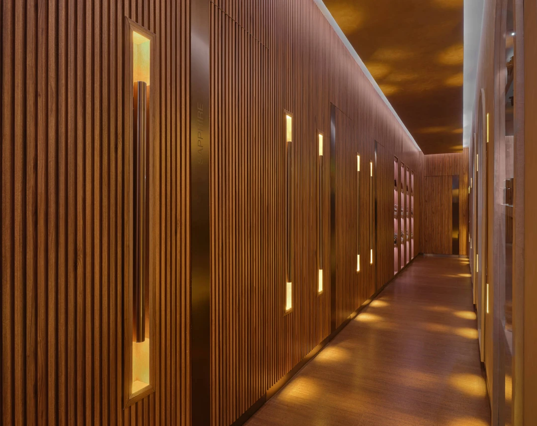Teak spa corridor with amber-lit recessed niches and arched mirror