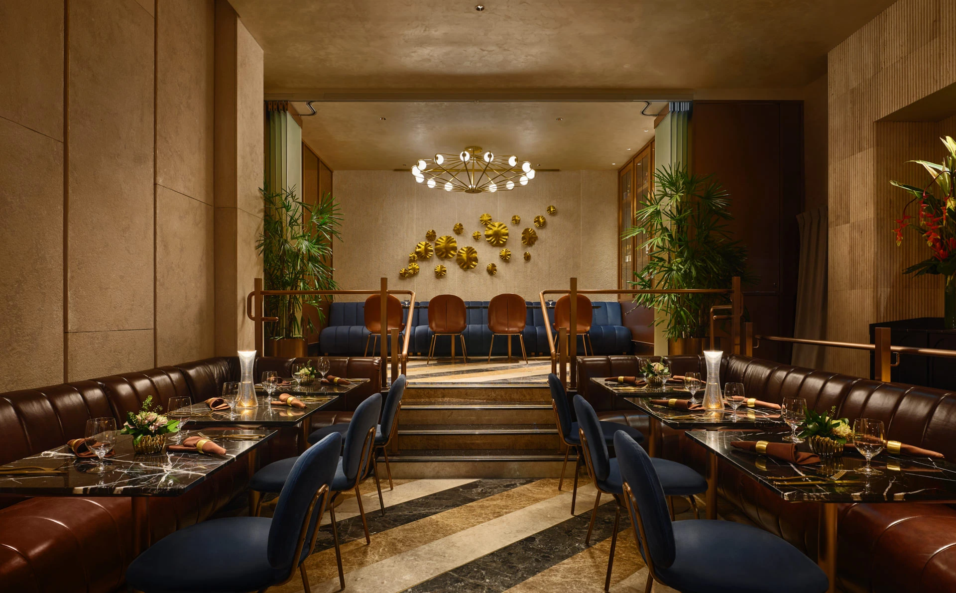 Private dining salon with sputnik chandelier and gold monstera wall art