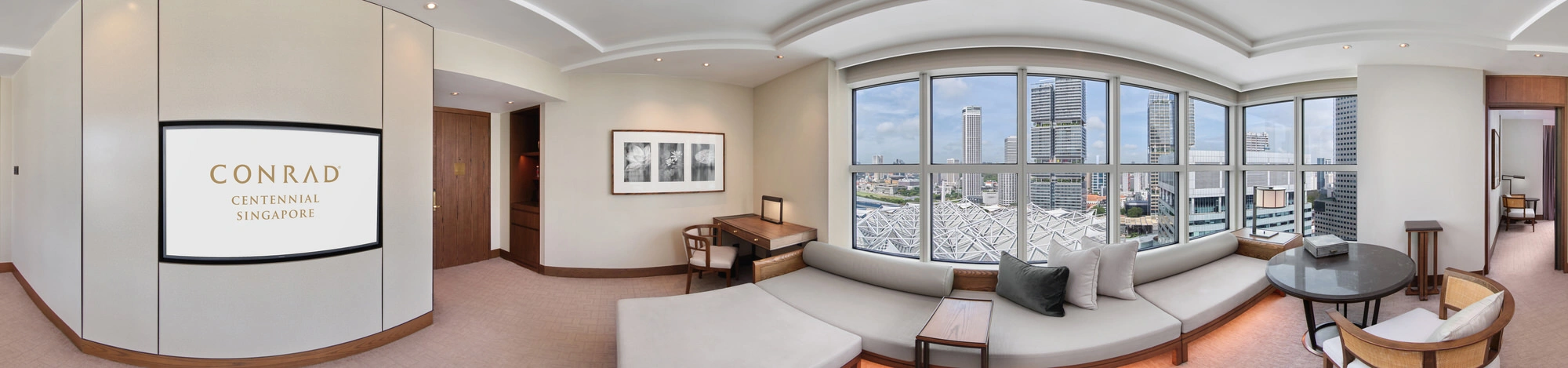 360 panorama of Conrad Centennial Singapore suite living area with L-shaped sofa and floor-to-ceiling city views