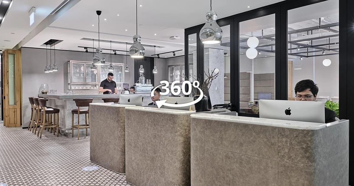 Screenshot of 360 virtual tour showing The Executive Centre coworking space at Ocean Financial Centre with marble hot desks, glass-walled meeting rooms, chrome pendant lamps, and a communal coffee bar