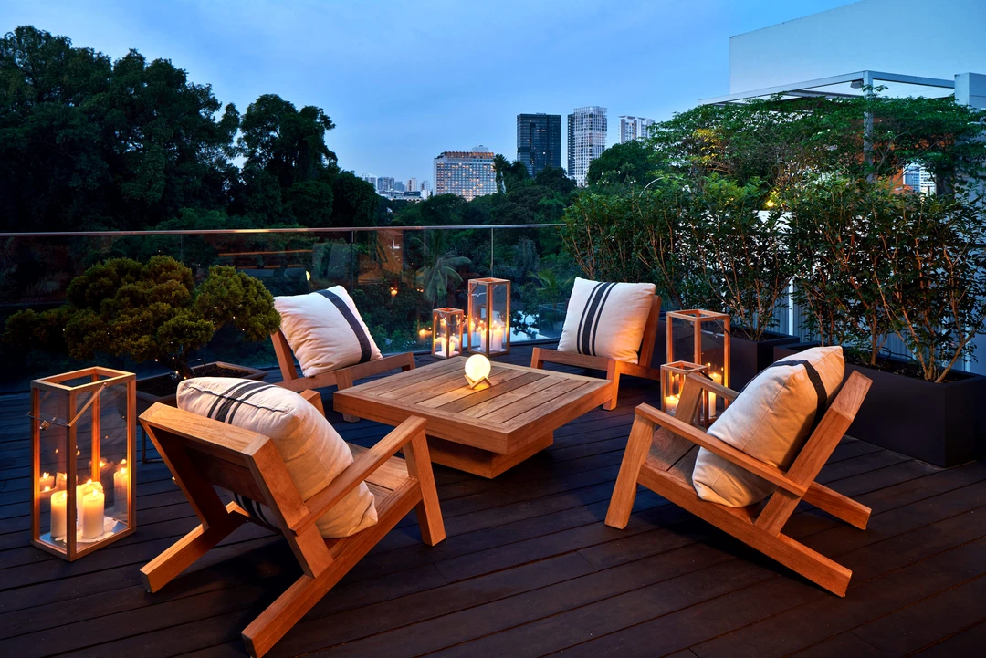 Sunset terrace with wooden furniture and greenery
