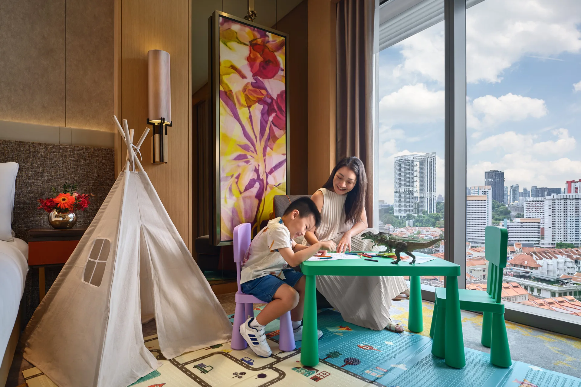 Sofitel Singapore City Centre family room lifestyle scene with parent and child beside a play tent and city skyline views