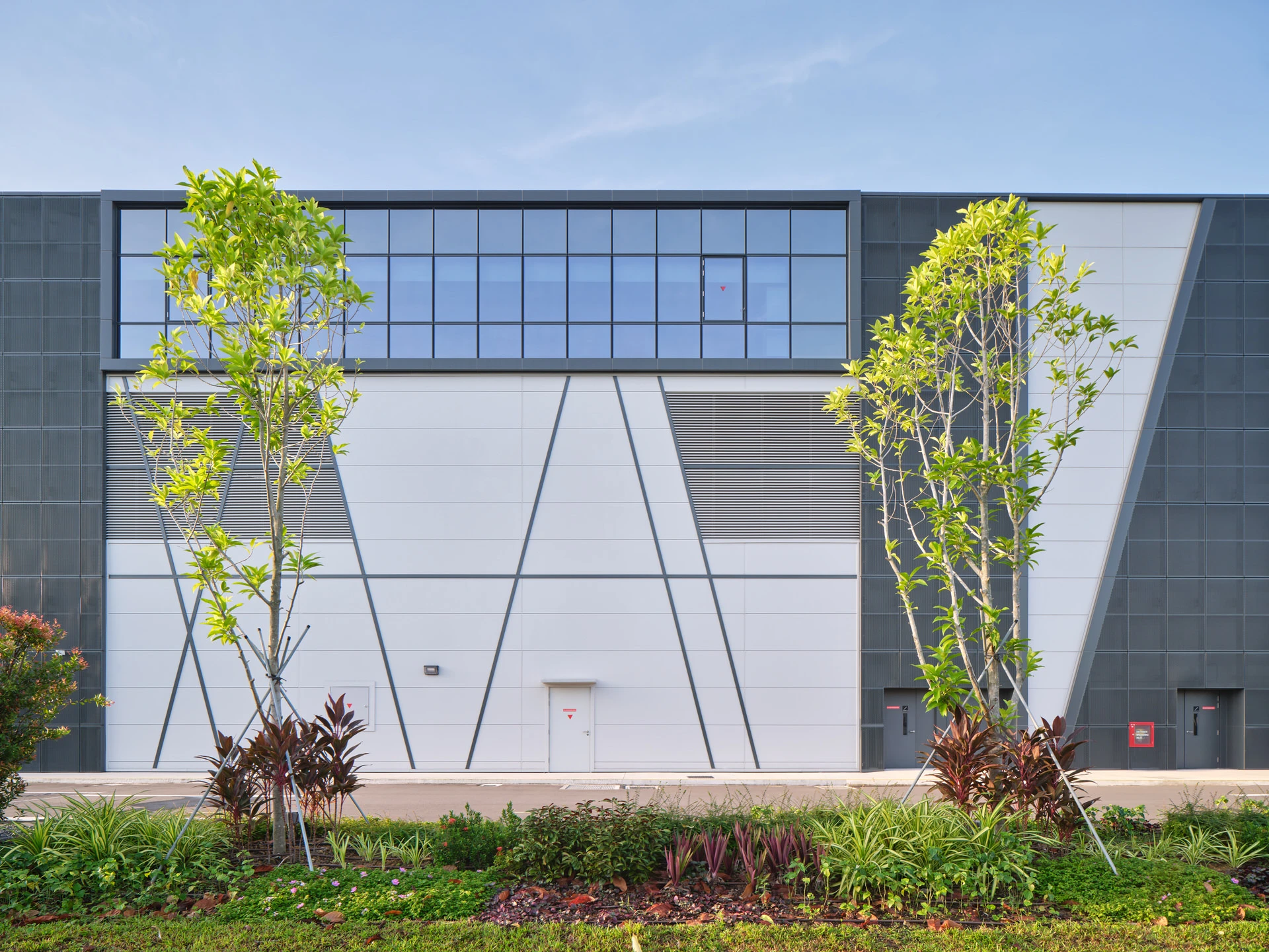 Facade detail with diagonal seam panels, louvres and clerestory glazing