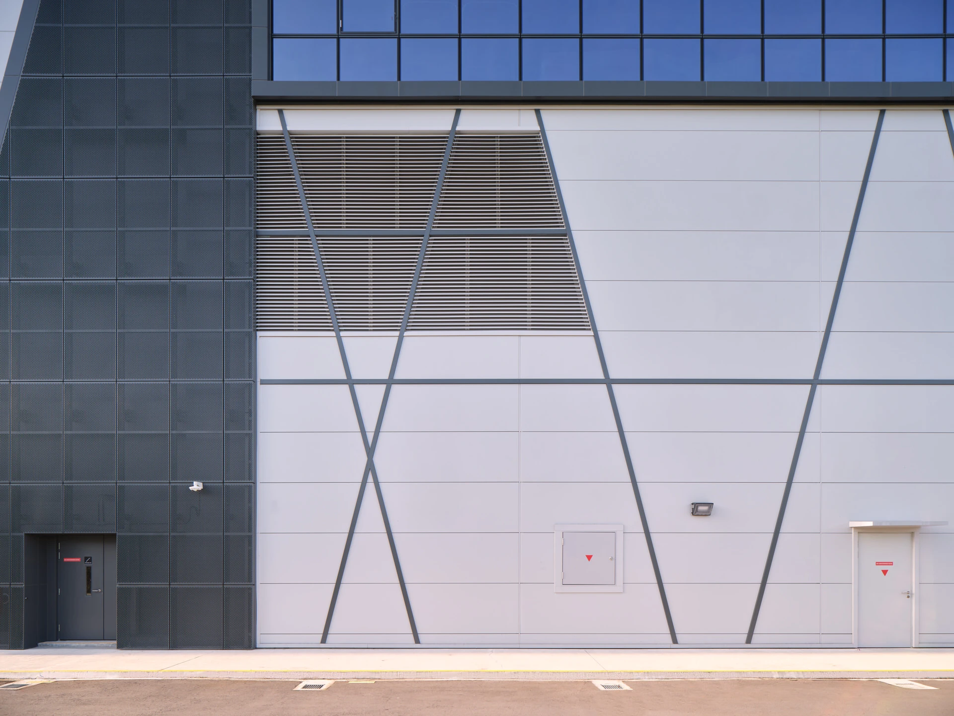 Perforated metal and white panel cladding detail with angular seams