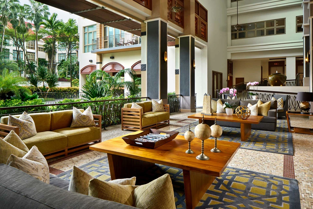 Lobby lounge with olive sofas and tropical courtyard garden view - Treetops Executive Residences Singapore interior photography