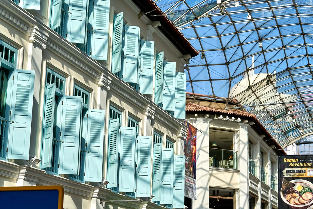 Turquoise louvered shutters on colonial facade with glass roof above - Bugis Junction Singapore detail photography