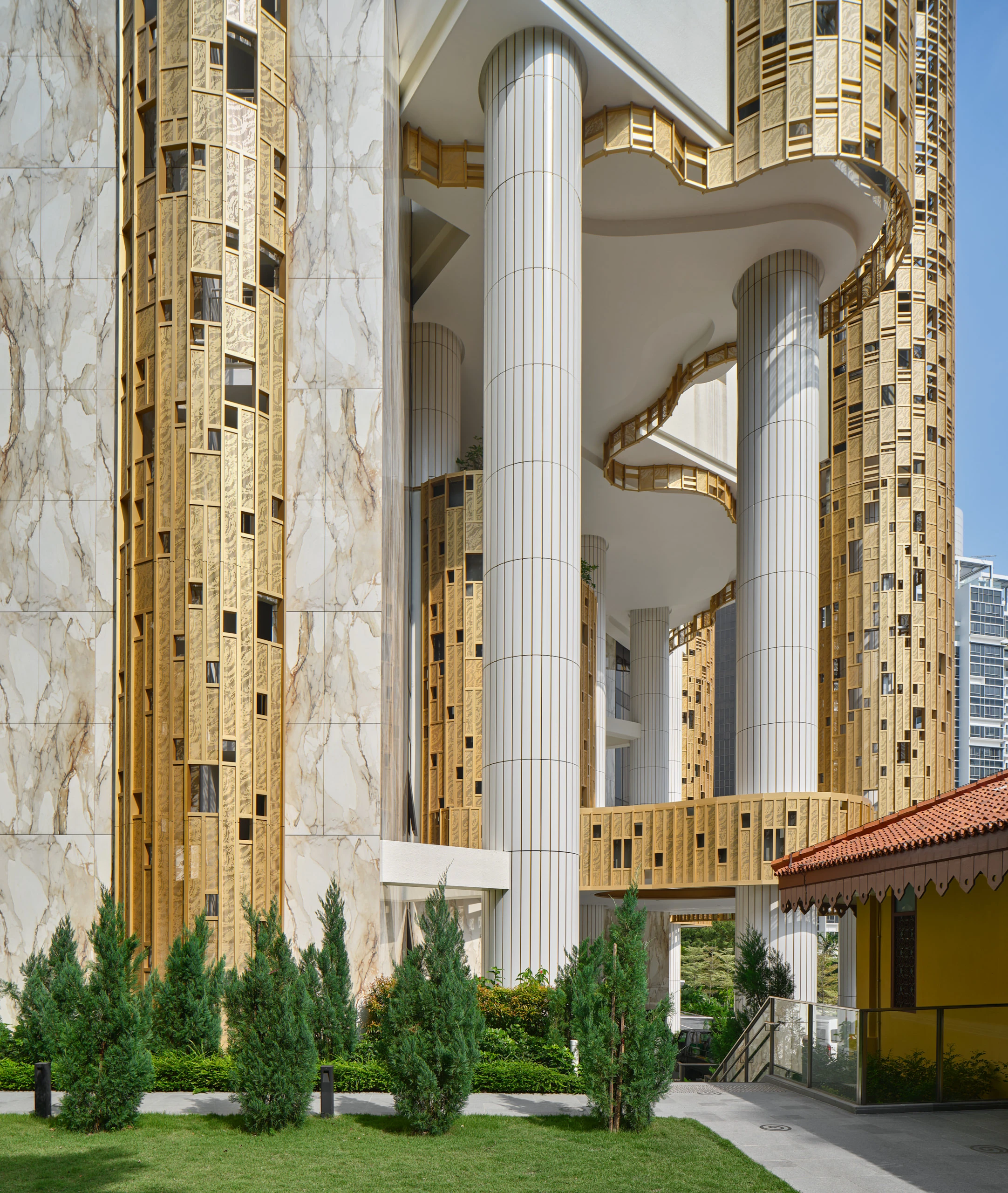 Klimt Cairnhill tower facade with Atlas Concorde gold mosaic tile cladding and marble-effect porcelain walls between white columns