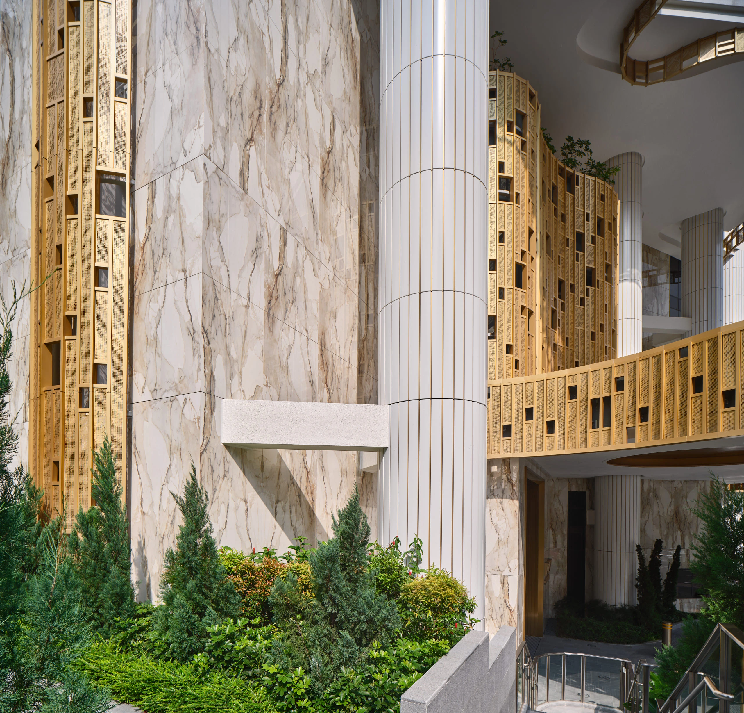 Atlas Concorde marble-effect porcelain wall panel and fluted column with gold mosaic tile cladding at Klimt Cairnhill