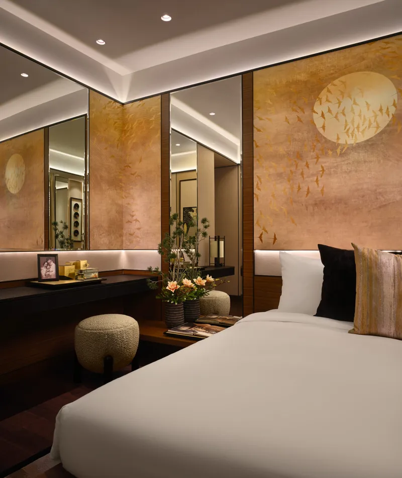 Luxurious bedroom with golden bird mural panels, mirrors and white bedding
