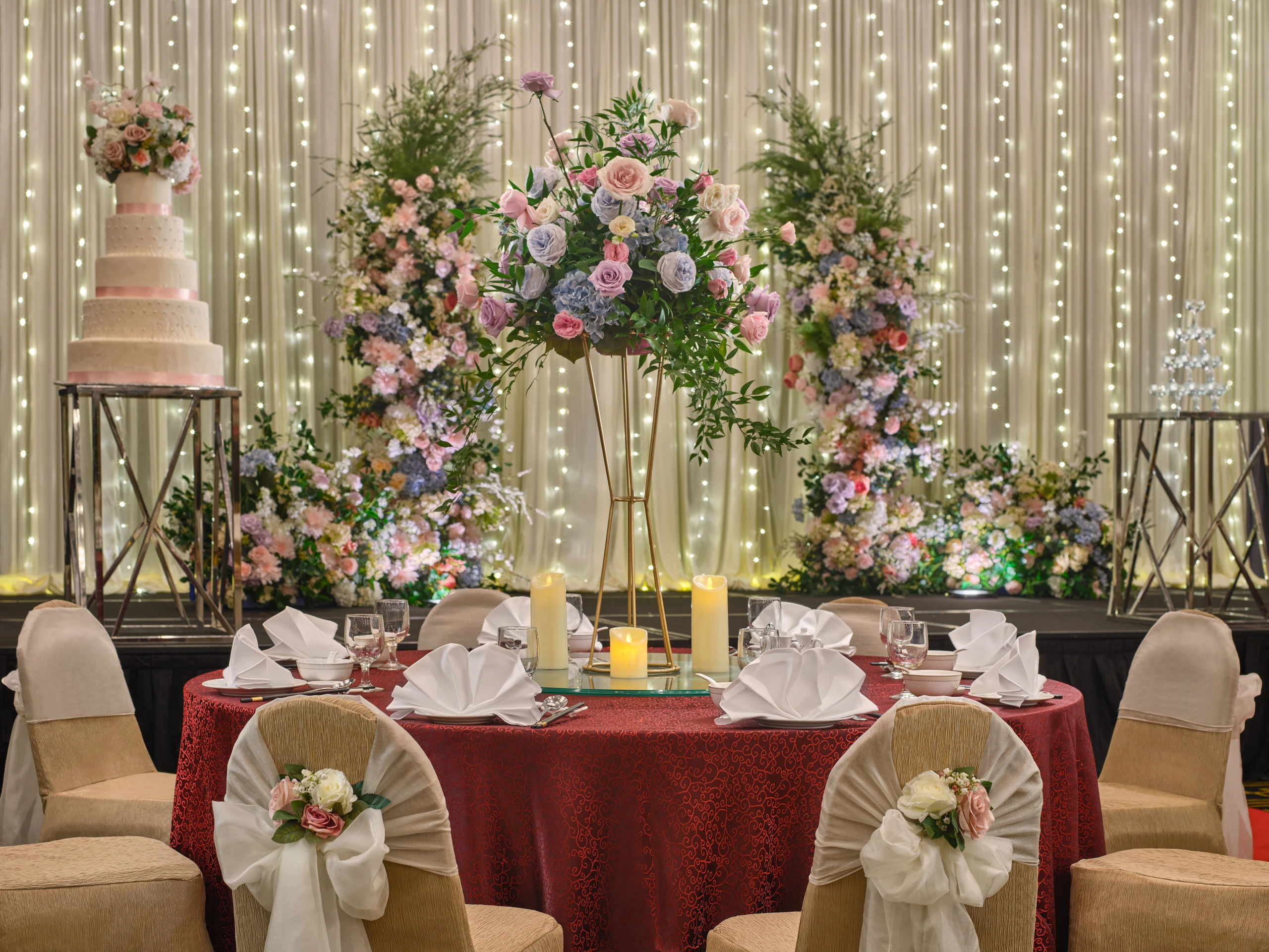 Rosa head table with rose arrangements and soft pink lighting