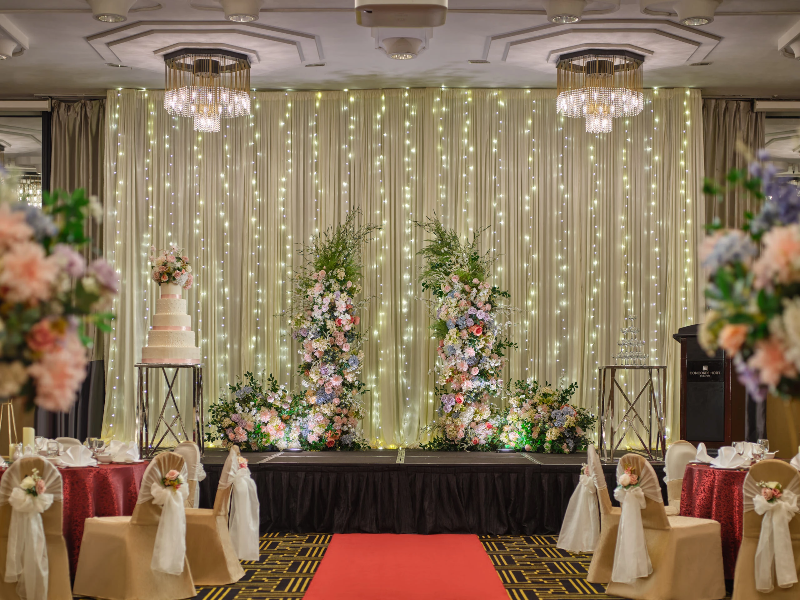 Rosa stage with draped backdrop and floral arch