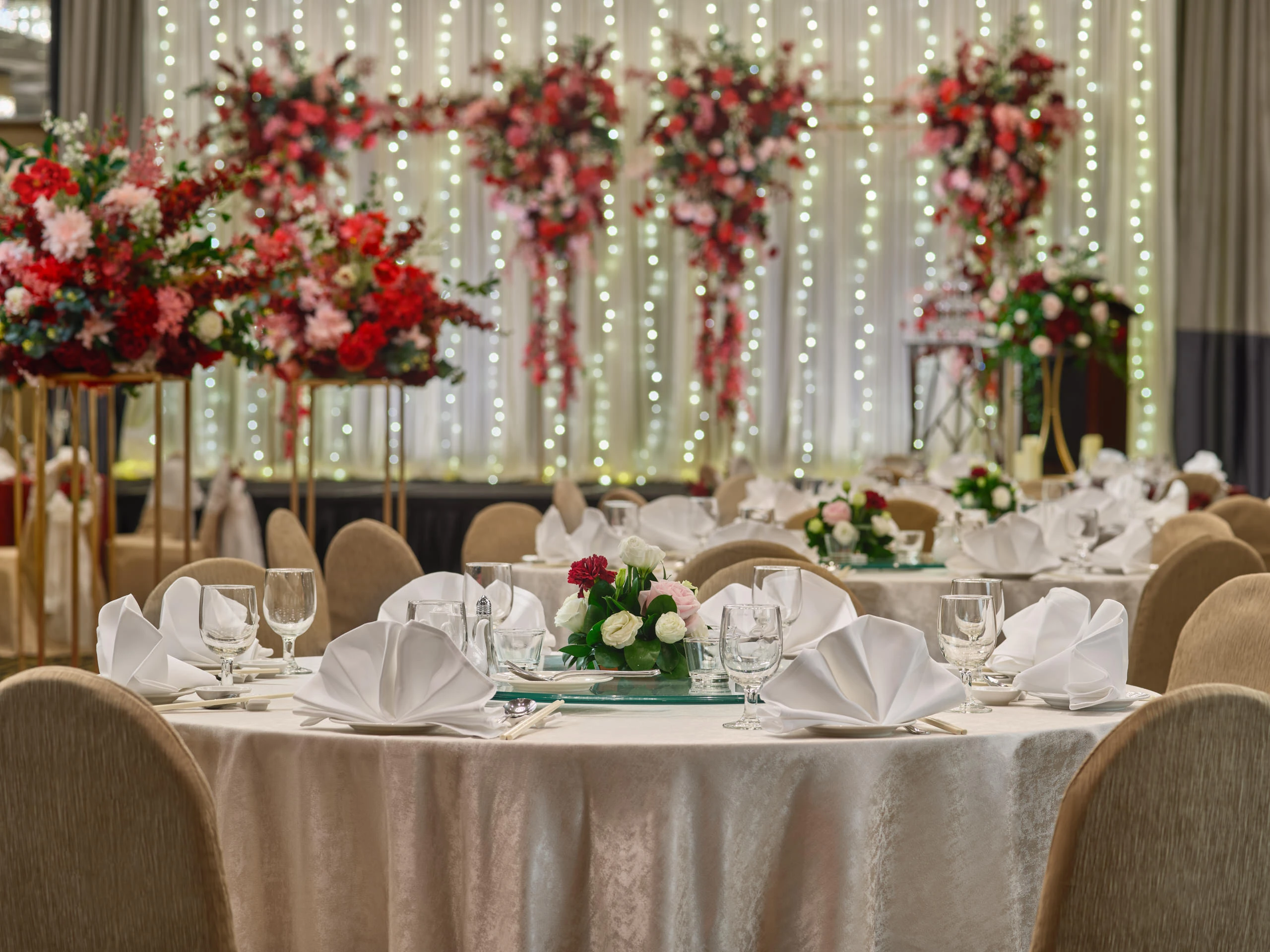 Scarlett guest table with red napkins, gold chargers and crystal centrepiece