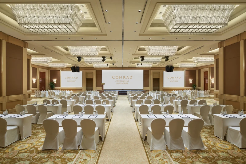 Ballroom classroom with crystal chandeliers, triple screens and stage