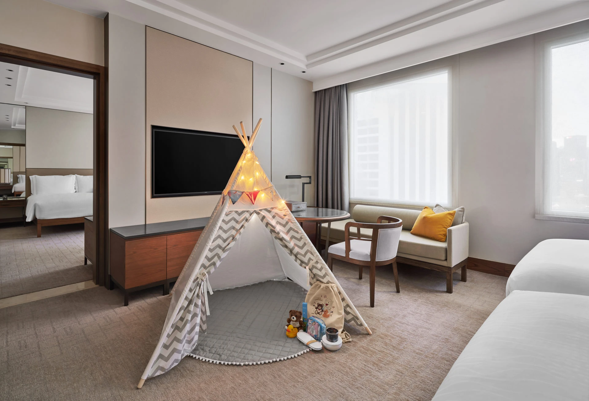 Family suite with chevron teepee and string lights in natural daylight
