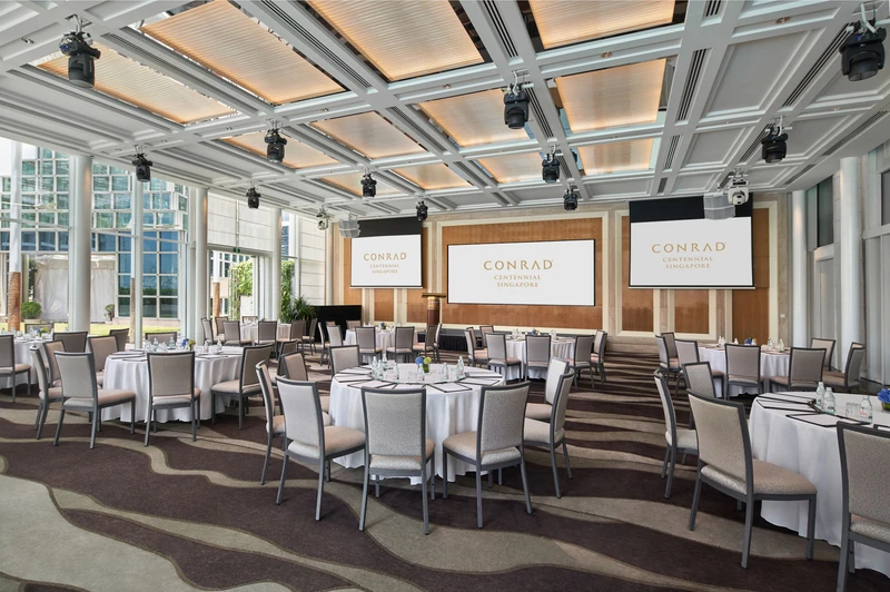 Event pavilion with banquet rounds, branded screens and floor-to-ceiling glass