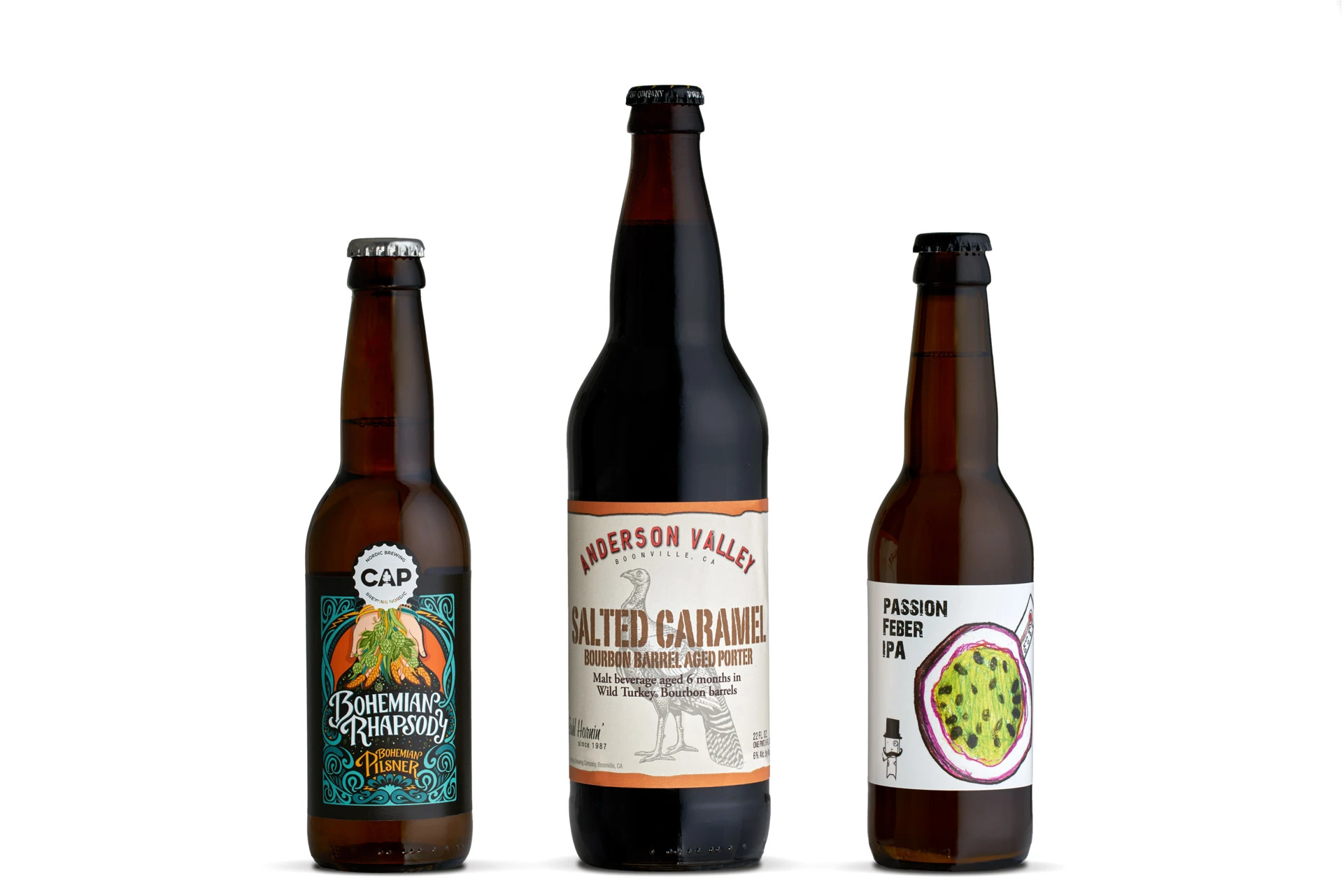 Three craft beer bottles on white background with backlit amber glass