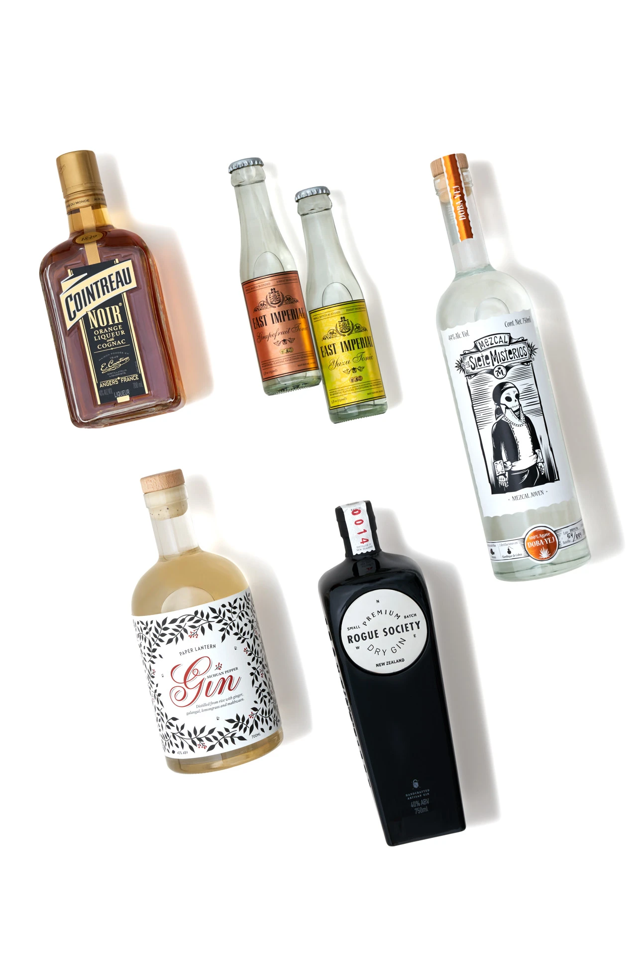 Five spirit bottles on white seamless background with soft studio lighting