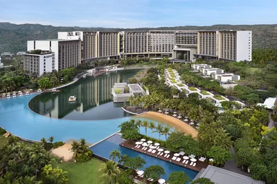 The Sanya EDITION aerial view from the sea showing oceanfront pool and property