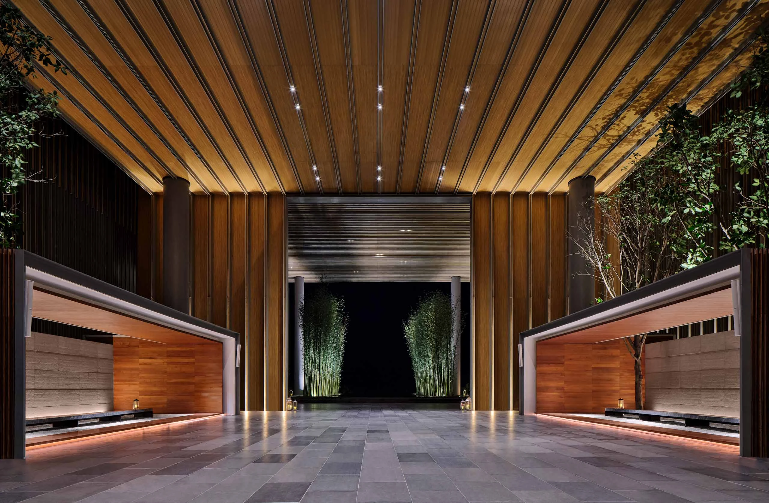 The Sanya EDITION entrance with timber-slatted porte-cochere, bamboo groves and dramatic uplighting