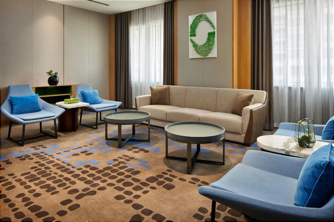 Executive lounge with blue armchairs, abstract artwork and natural light
