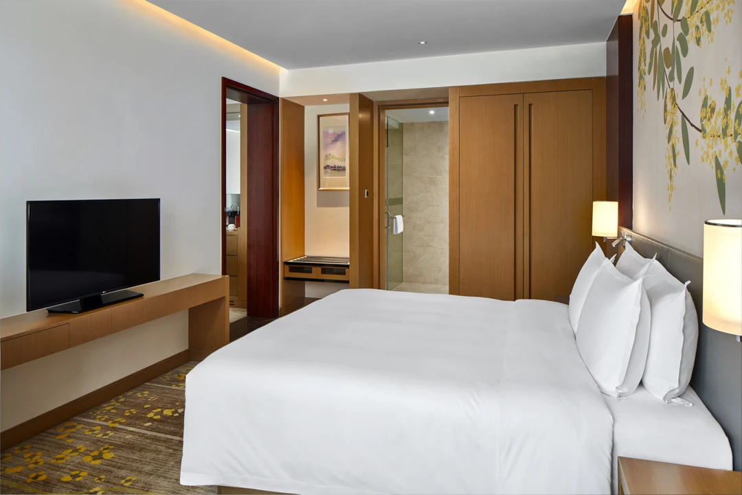 Suite bedroom with botanical wall mural and glass bathroom door