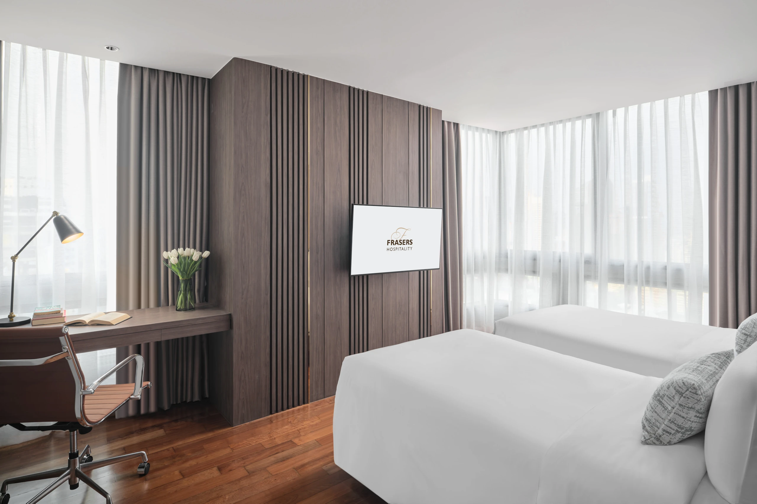 King bedroom with orange bolster, work desk and mauve drapes