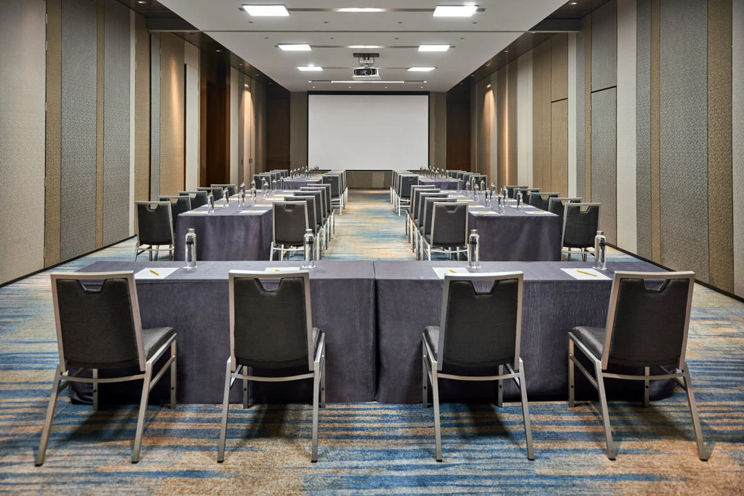 Conference room in classroom setup with projector and striped panels
