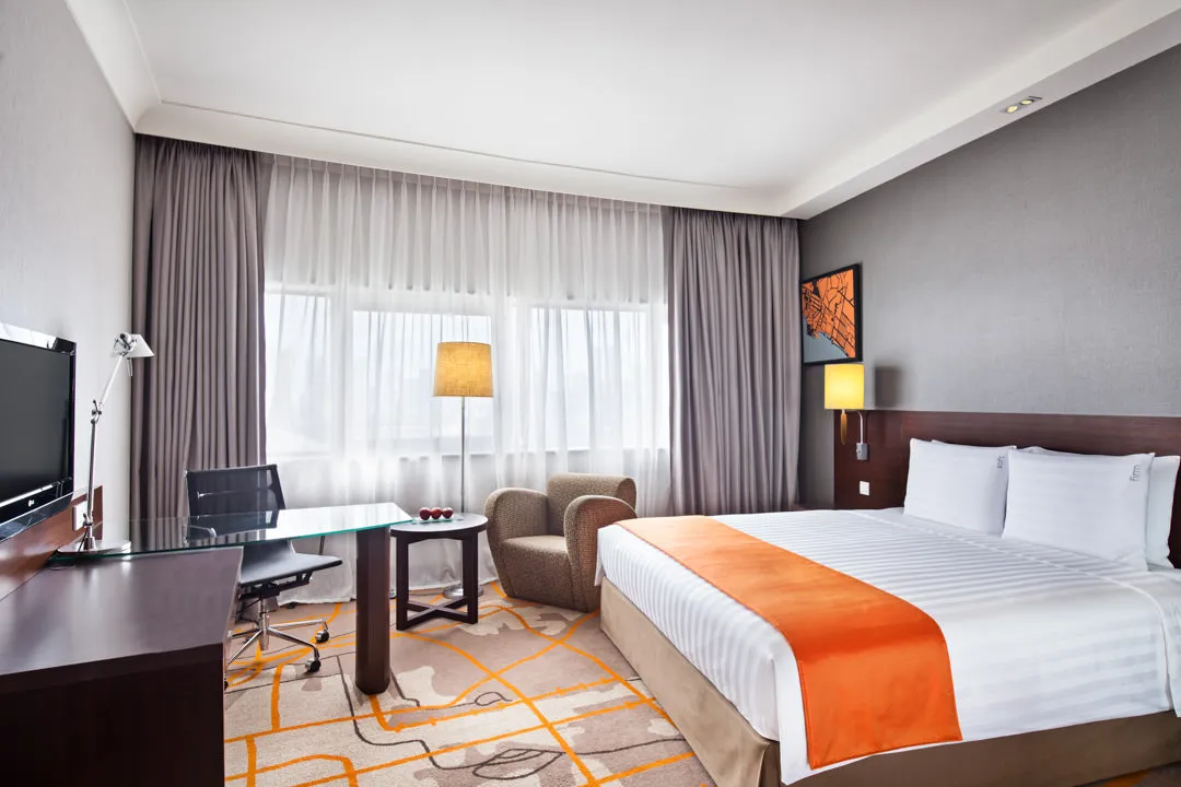Executive room with king bed, patterned carpet and city views — Holiday Inn Atrium Singapore interior photography
