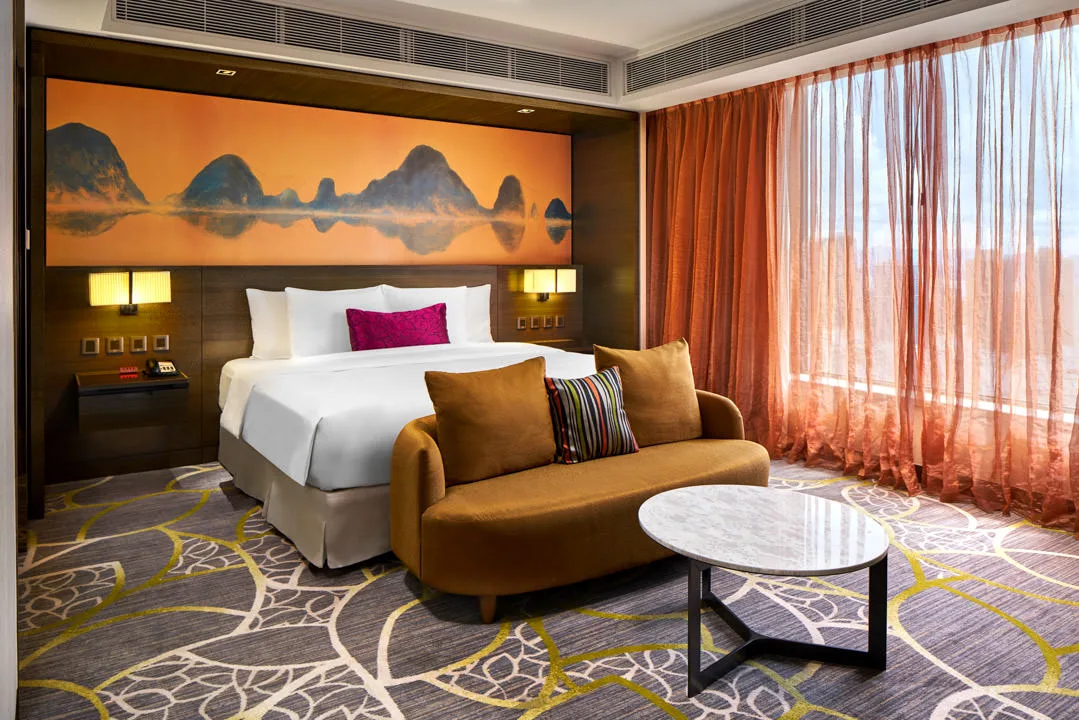 King room with orange karst mural headboard and mustard loveseat — Crowne Plaza Hong Kong Kowloon East hotel photography