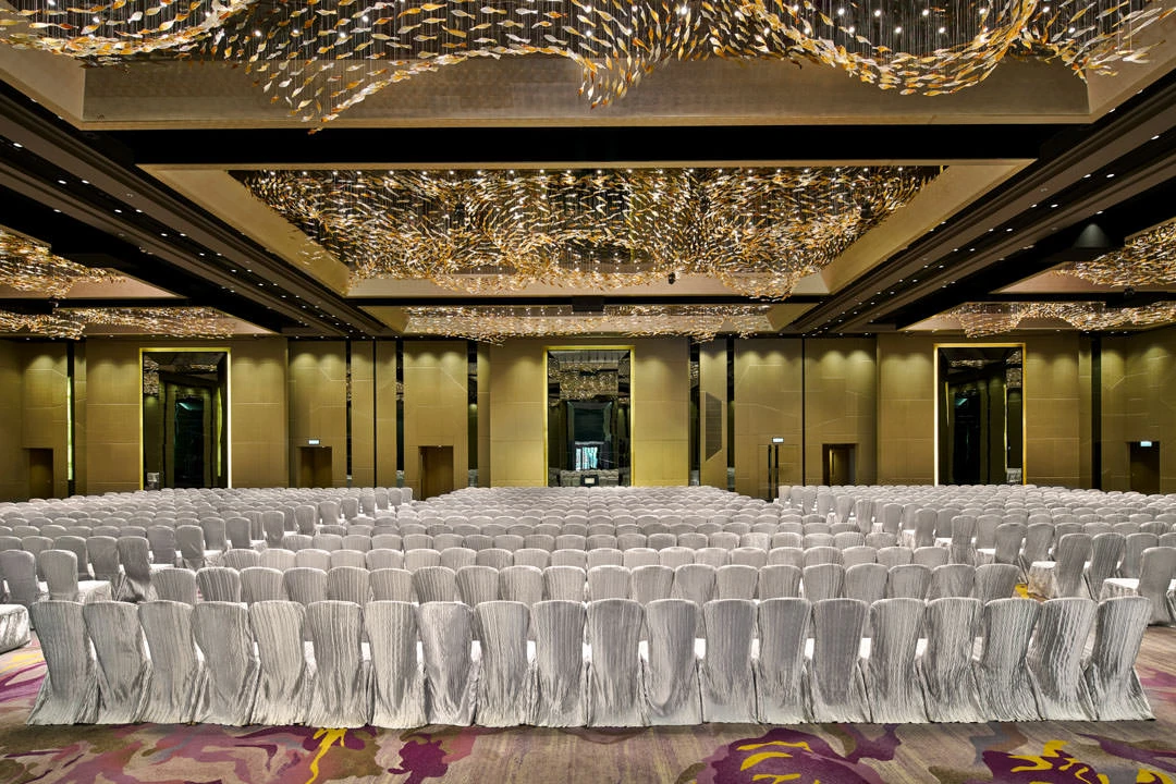 Theatre-style ballroom with swirling gold ceiling and silver chairs — Crowne Plaza Hong Kong event photography