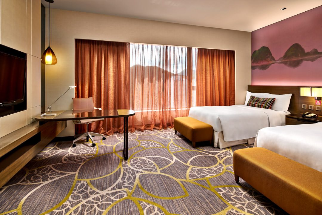 Twin room with pink mountain mural, mustard ottomans and pendant light — Crowne Plaza Hong Kong hotel photography