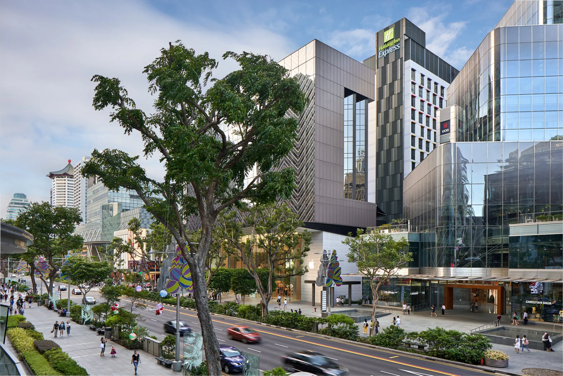 Holiday Inn Express tower above Orchard Road retail district with rain trees — Singapore hotel photography