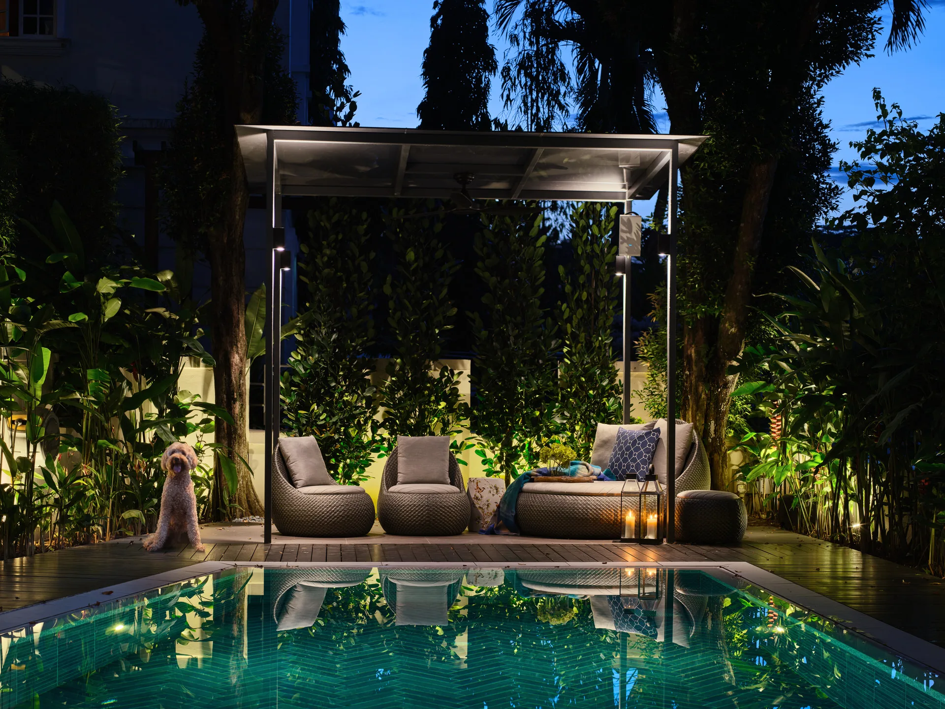 Tropical poolside pavilion at twilight with rattan loungers and LED lighting - Holland Green Singapore architectural photography