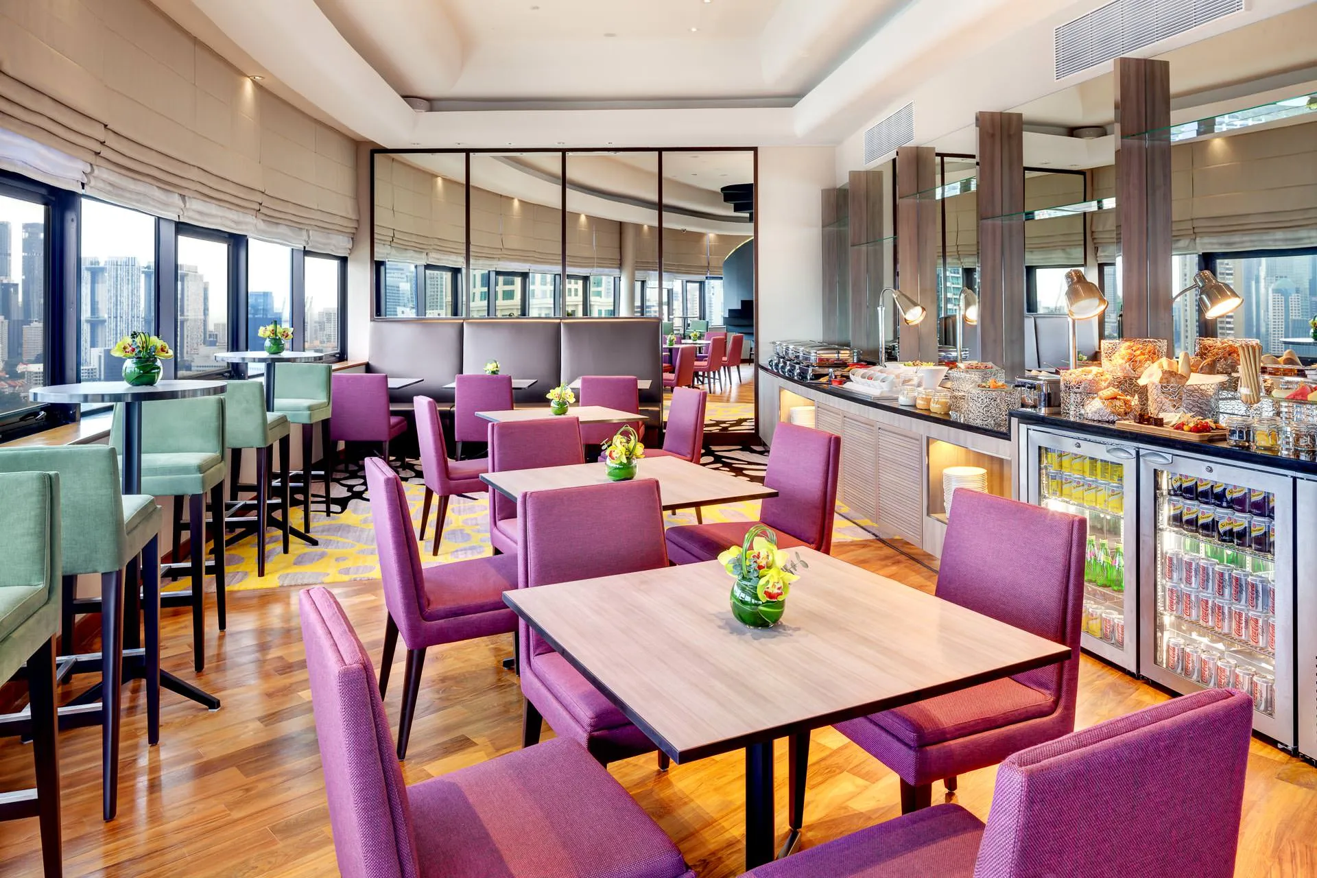 Executive lounge with purple chairs, buffet counter and city skyline view — Holiday Inn Atrium hospitality photography