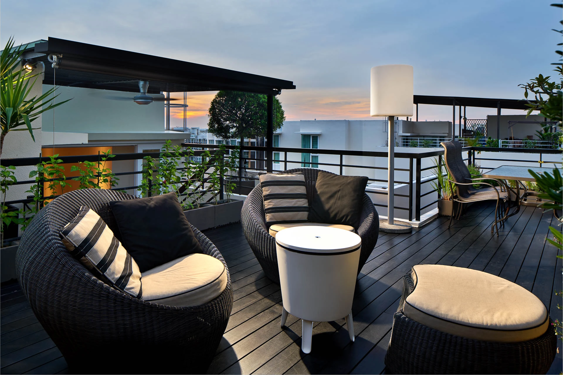 Rooftop terrace with wicker pod chairs and sunset sky — Simei Rise Singapore residential interior photography