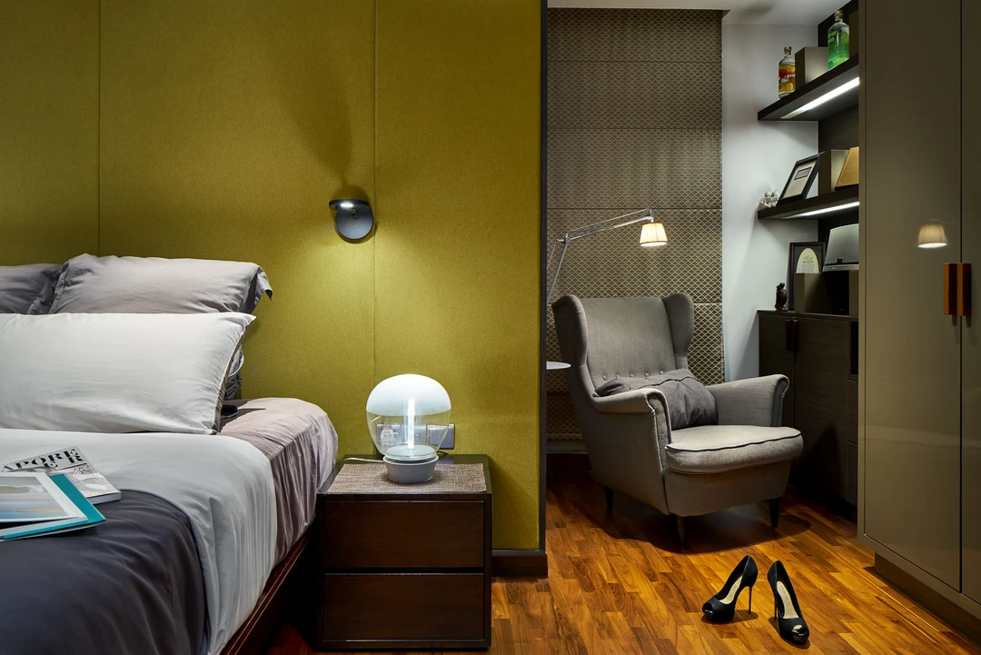 Master bedroom with chartreuse headboard and grey wingback reading chair — Simei Rise Singapore interior photography