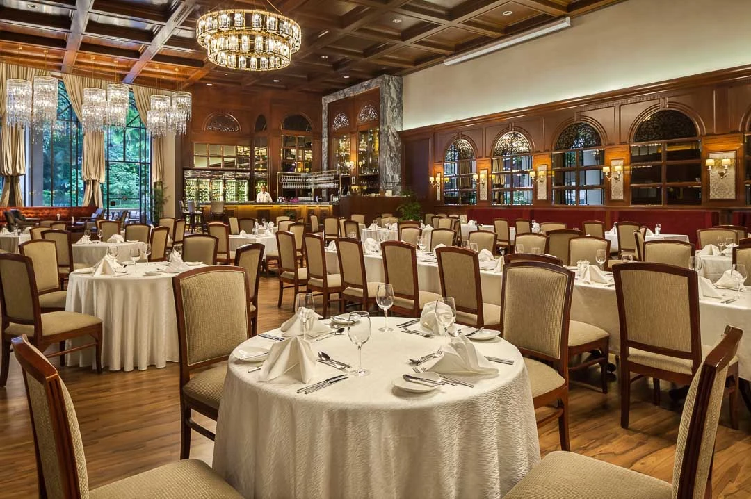 Churchill Room with dark panelling, crystal chandeliers and white linen