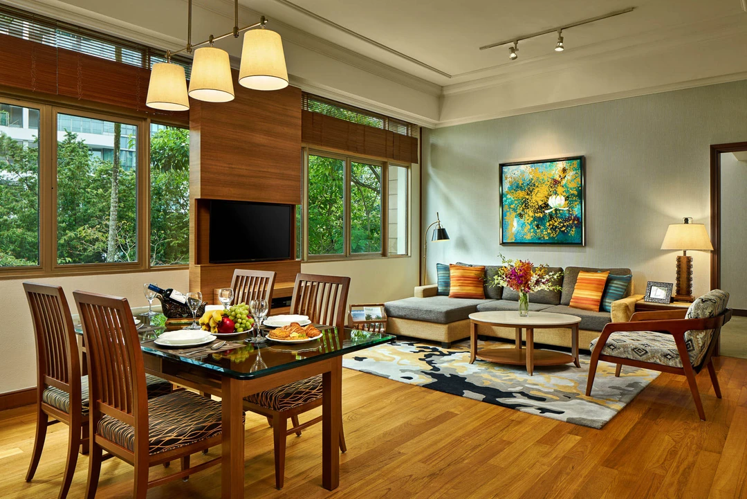 Two-bedroom suite with L-shaped sofa, glass dining table and wrap-around windows - Treetops Singapore hospitality photography