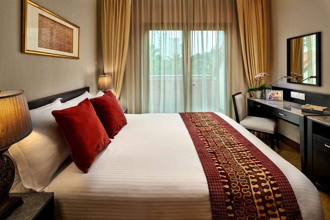 King bedroom with red cushions, ornate lamps and gold curtains - Treetops Executive Residences Singapore interior photography