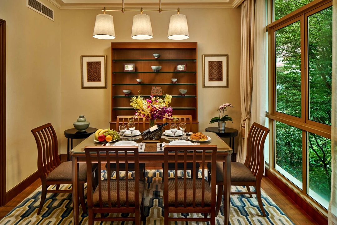 Dining table with brass pendant light and garden view display shelf - Treetops Singapore hospitality photography