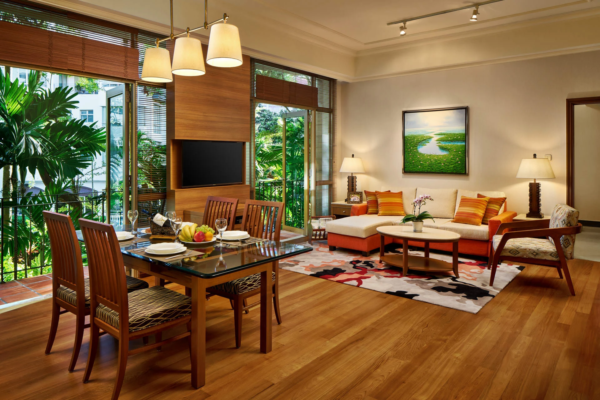 Open-plan living with glass dining table, sectional sofa and double-height windows - Treetops Singapore hospitality photography