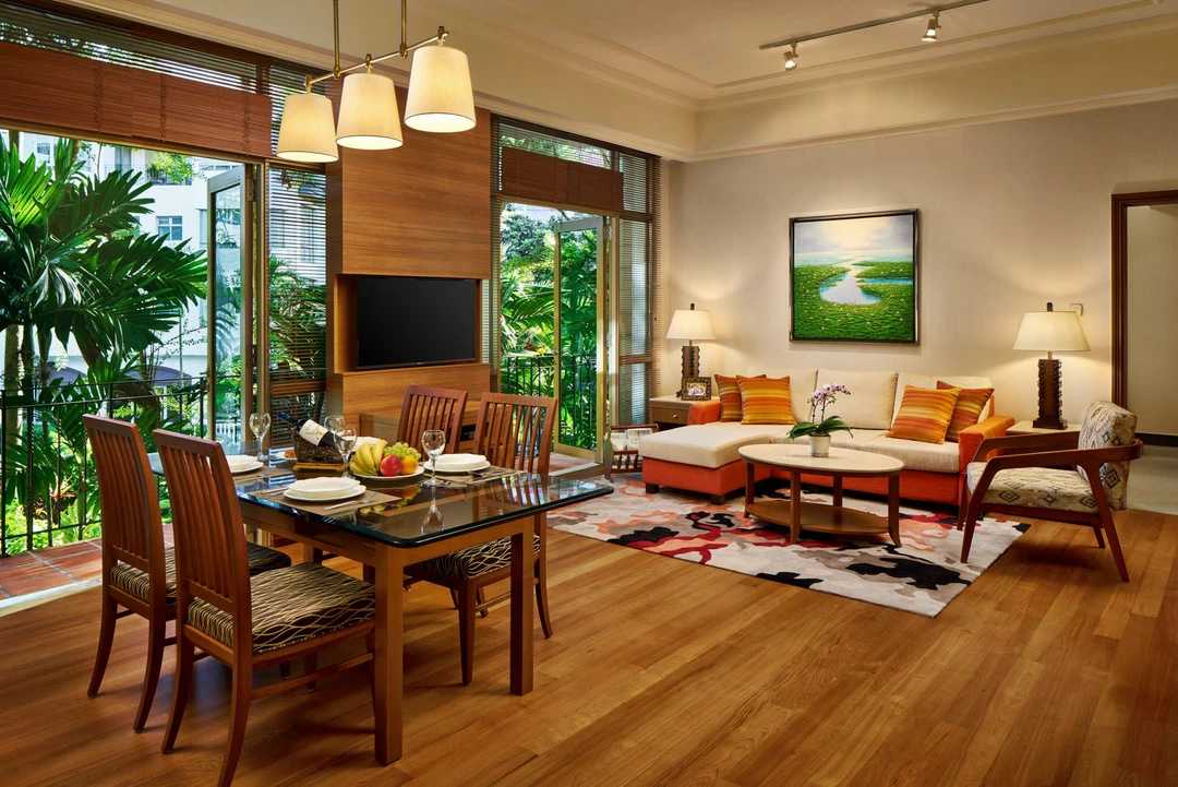 Open-plan living with glass dining table, sectional sofa and double-height windows - Treetops Singapore hospitality photography