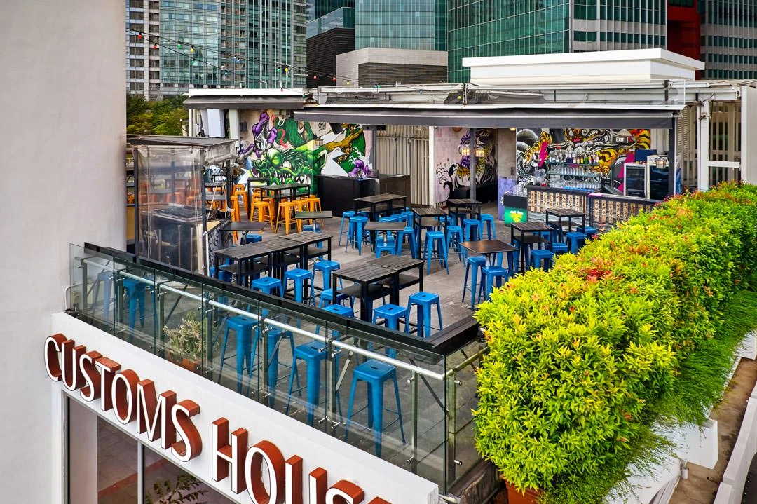 Rooftop bar with blue stools, Customs House sign and graffiti walls