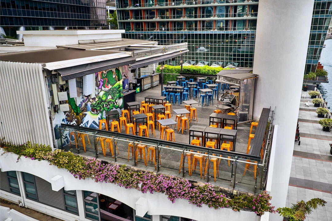 Rooftop terrace with orange stools, dragon mural and glass balustrade